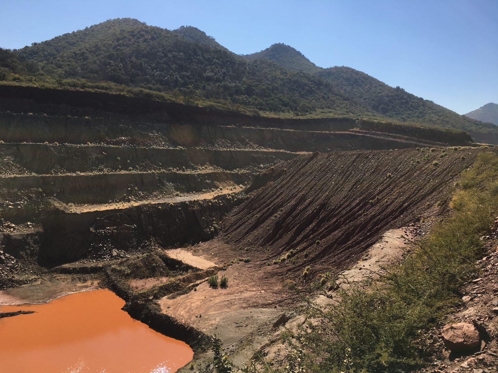 Open-pit benches cut into a hillside